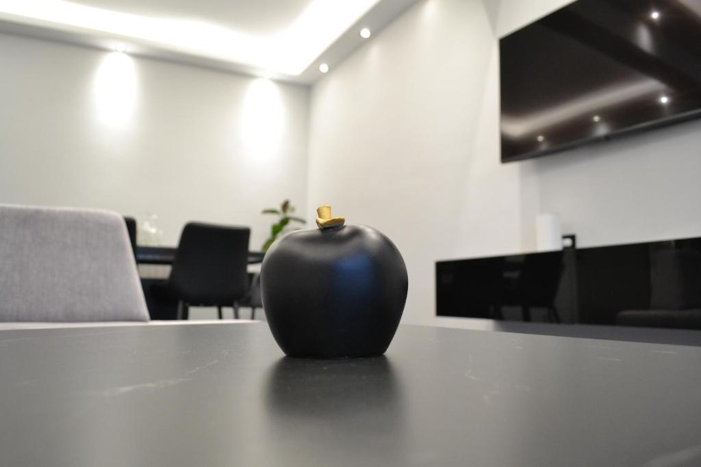 a black vase sitting on top of a table at kaleos in Néa Khilí