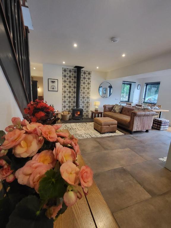a living room with a couch and a table with flowers at Coach House Innellan in Innellan