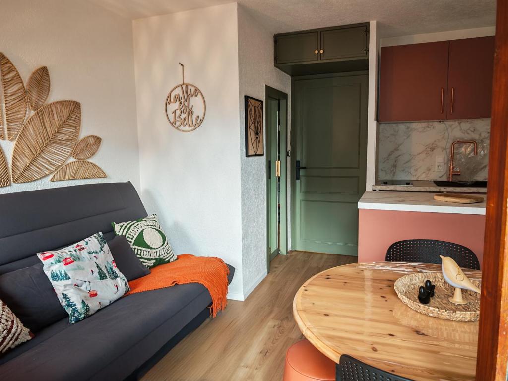 a living room with a couch and a table at Le Bon' Appart studio proche centre Châtel in Châtel