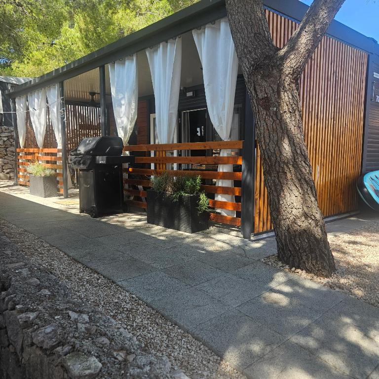 a house with a fence and a tree in front of it at FM mobile - Oaza mira, Drage in Drage