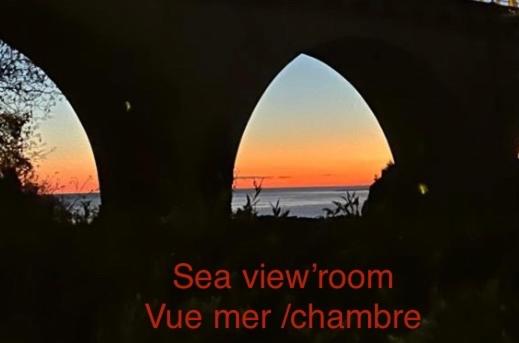 Una imagen de una puesta de sol vista a través de dos arcos. en STUDIO pied village EZE - dans VILLA - Parking Gratuit, en Èze