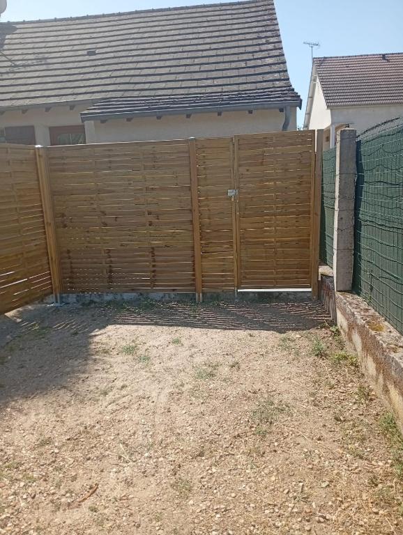 a wooden fence in front of a house at Maison 2 - entre ville et verdure in Saint-Pryvé-Saint-Mesmin