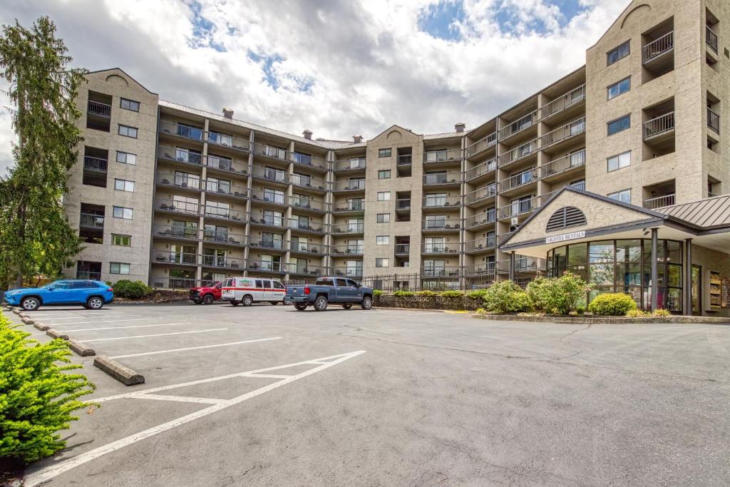 a parking lot in front of a large apartment building at Modern Condo, W Fireplace & Pool In Gatlinburg! in Gatlinburg