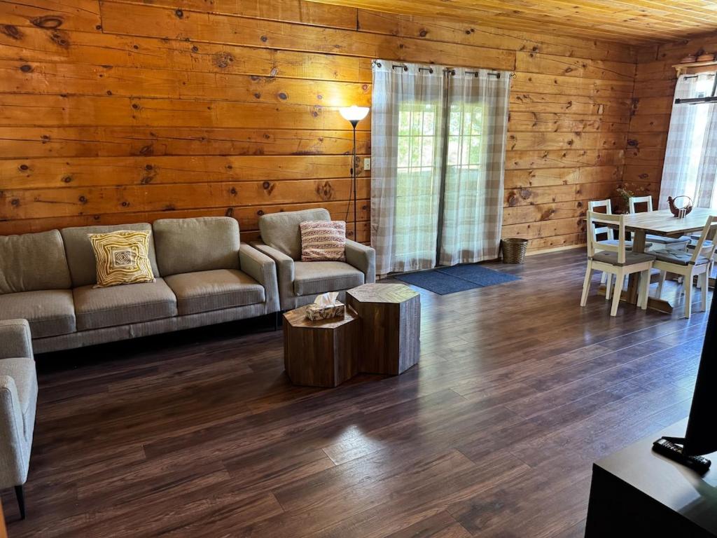 una sala de estar con un sofá y una mesa en Log Cabin with Tiny Farm, en Dunnville