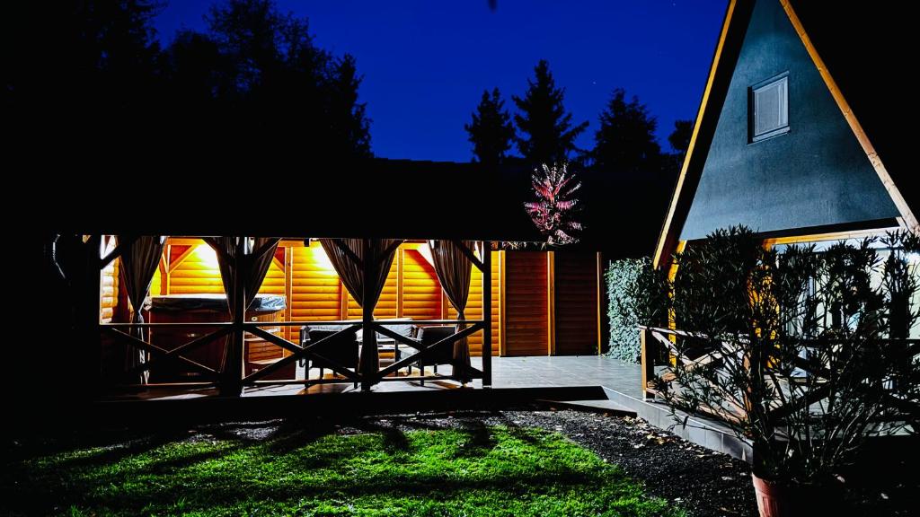 a house with a black and orange facade at night at Tiszaparti Meseház in Tiszalök