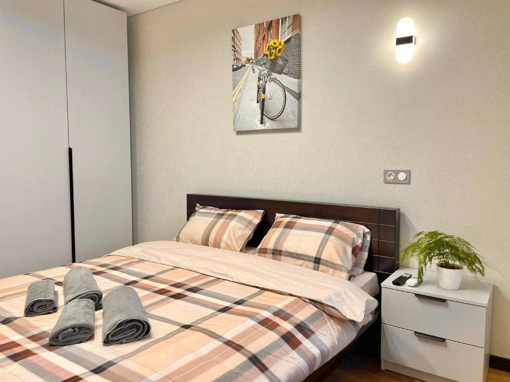 a bedroom with a bed with flip flops on it at Voloshyna Central Loft in Ivano-Frankivsk