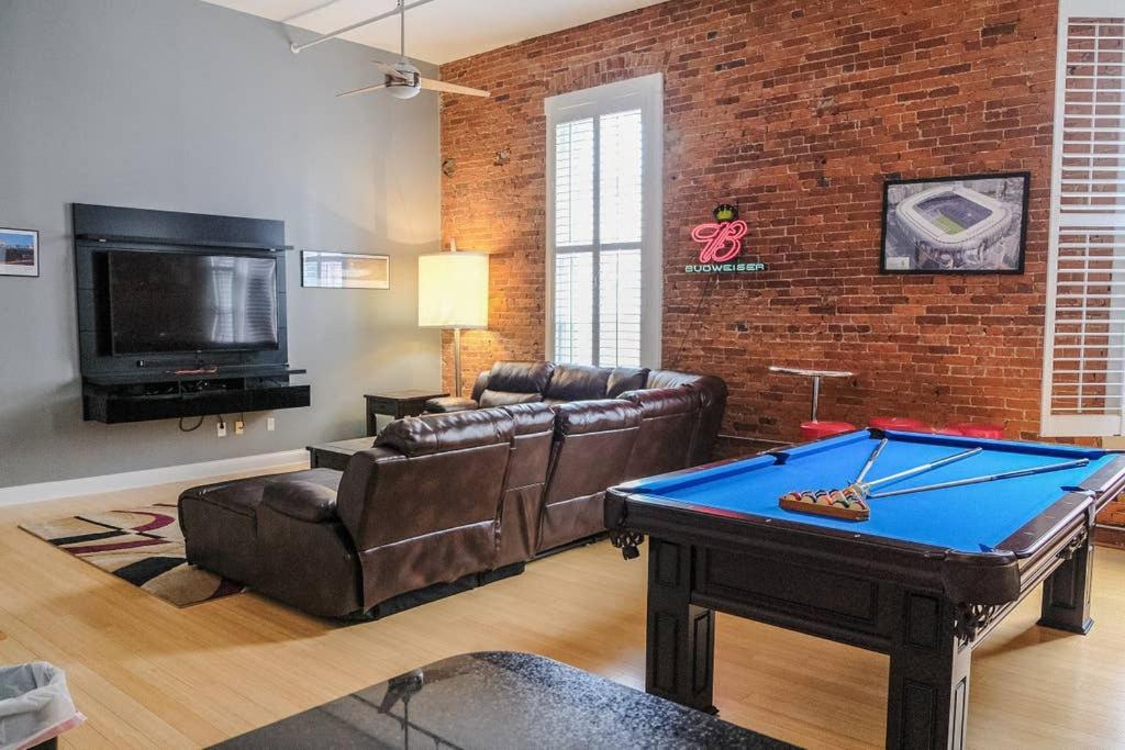 a living room with a pool table and a brick wall at 1800 Sq Ft Loft Downtown Near Convention Center in Indianapolis