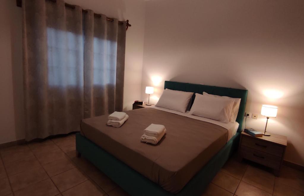 a bedroom with a bed with two towels on it at Epiphany Moudros Apartment in Moúdhros