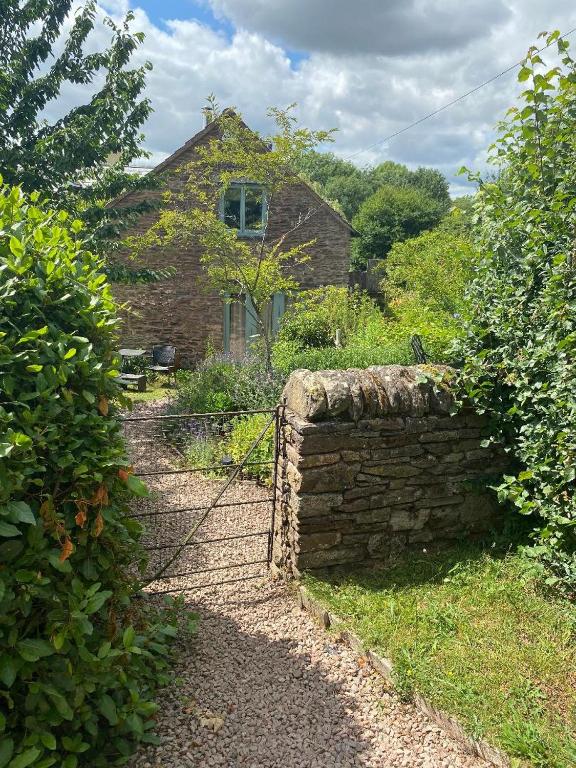 an old brick house with a gate in front of it at Little Llanvolda in Saint Maughans