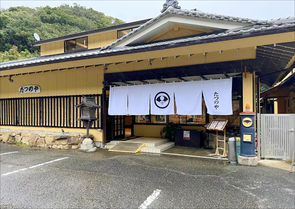 budynek z szyldem na froncie w obiekcie 民宿食事処 たつのや w mieście Shirahama