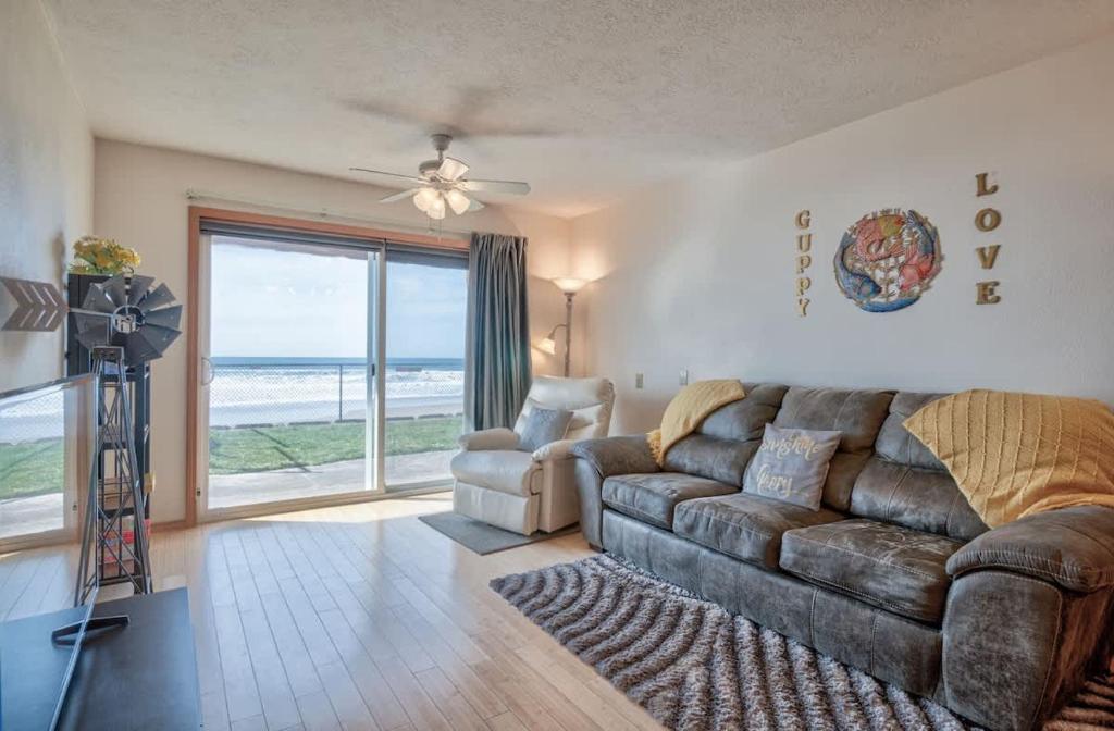 sala de estar con sofá de cuero y silla en Beachfront Suite On The Ground Floor - Sleeps 4 - Pool and Sauna, en Lincoln City