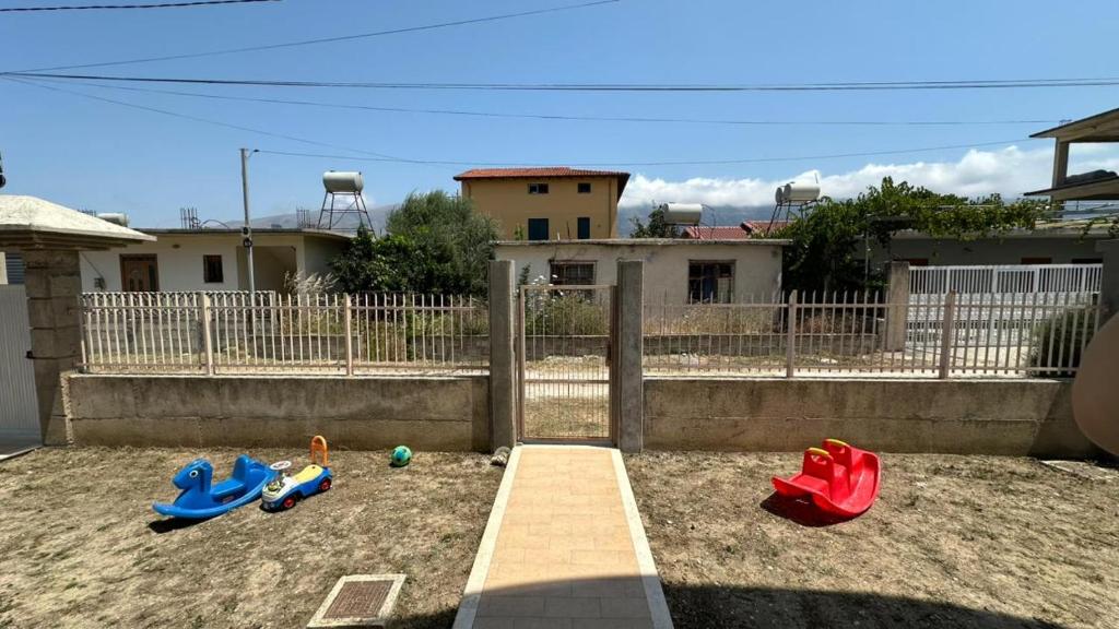 three childrens toys in the sand in a backyard at Victoria's Apartments in Orikum