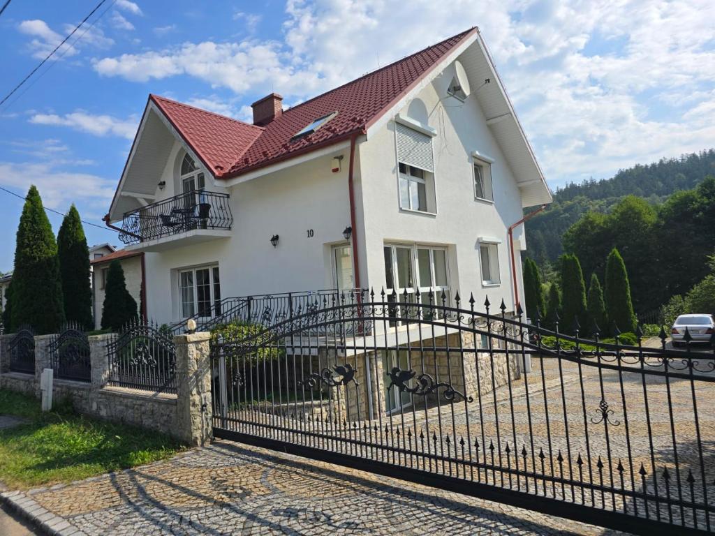a white house with a fence at Willa na Ogrodowej in Długopole-Zdrój