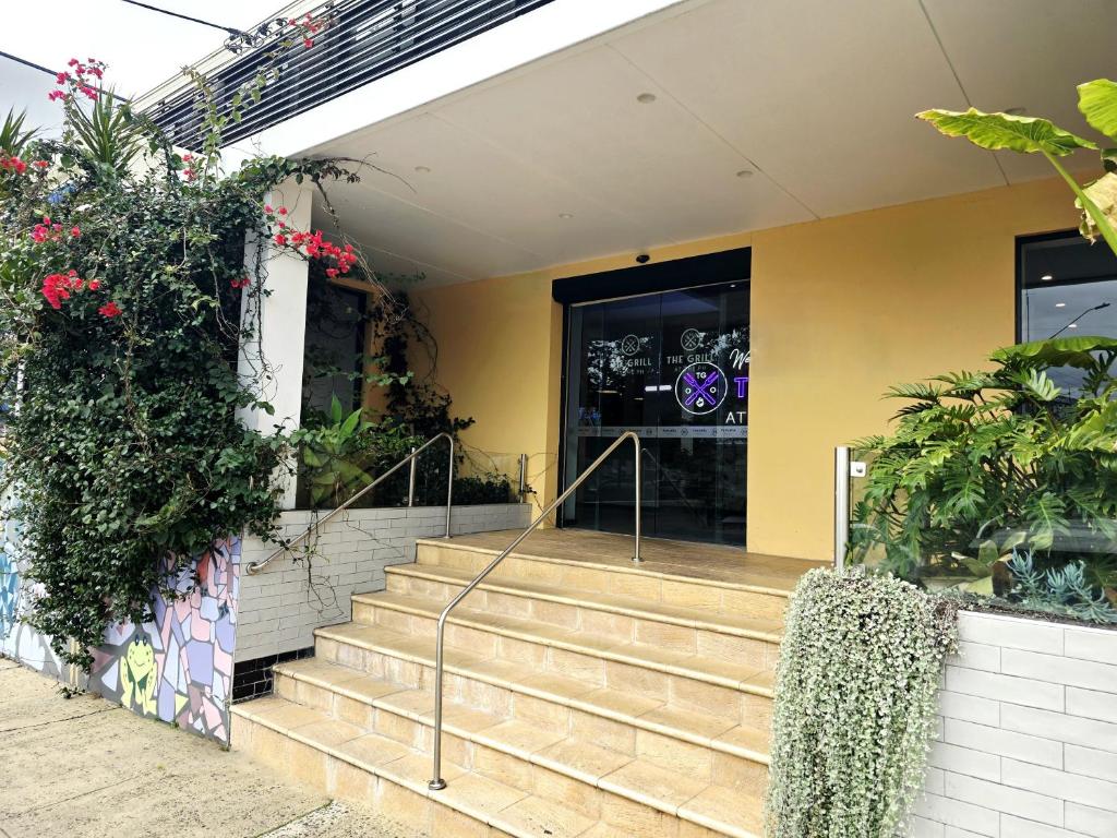 a store front with stairs in front of a building at Panania Hotel Sydney in Panania