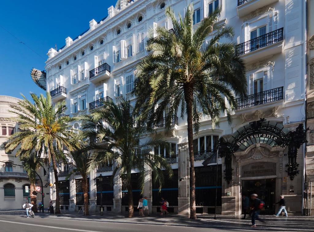 un grande edificio bianco con palme di fronte di One Shot Palacio Reina Victoria 04 a Valencia