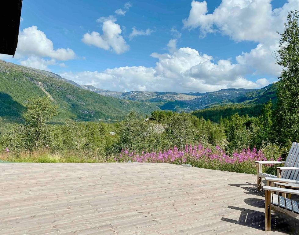 a bench sitting on a patio with mountains in the background at Stylish Cabin In Scenic Surroundings in Skare