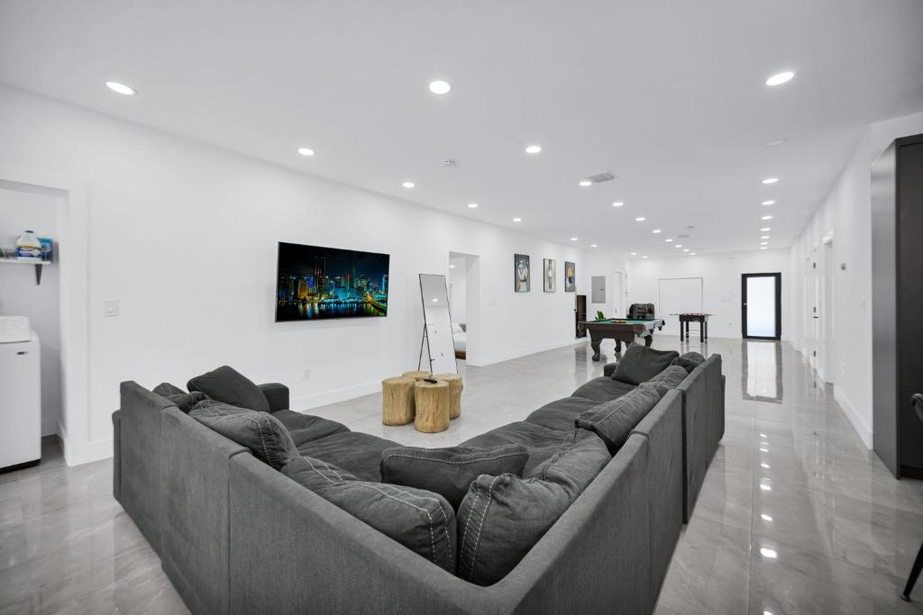 - un salon avec un grand canapé au milieu dans l'établissement Lux Modern 4BR Villa with Pool in Miami, à Miami