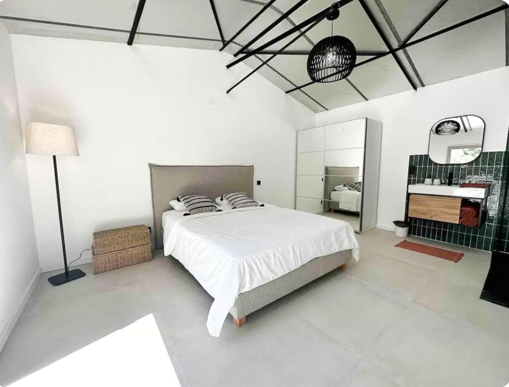 une chambre blanche avec un lit et un miroir dans l'établissement Peaceful Villa Between Sea And Pyrenees, à Perpignan