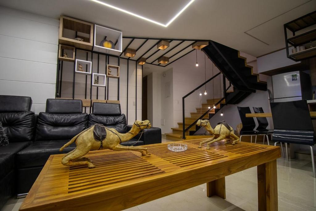 un soggiorno con un tavolo di legno e un divano di Penthouse de Lujo con Jacuzzi y Vista a Itagüí