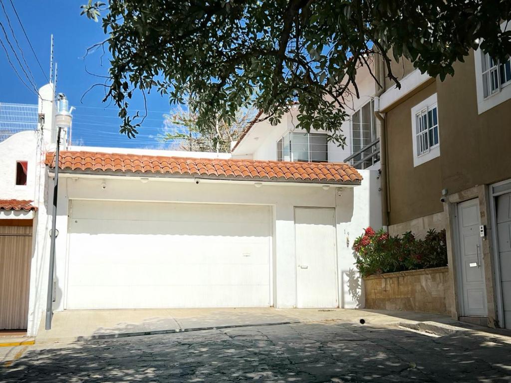 eine weiße Garagentür vor einem Haus in der Unterkunft Casa YOKO in Oaxaca de Juárez