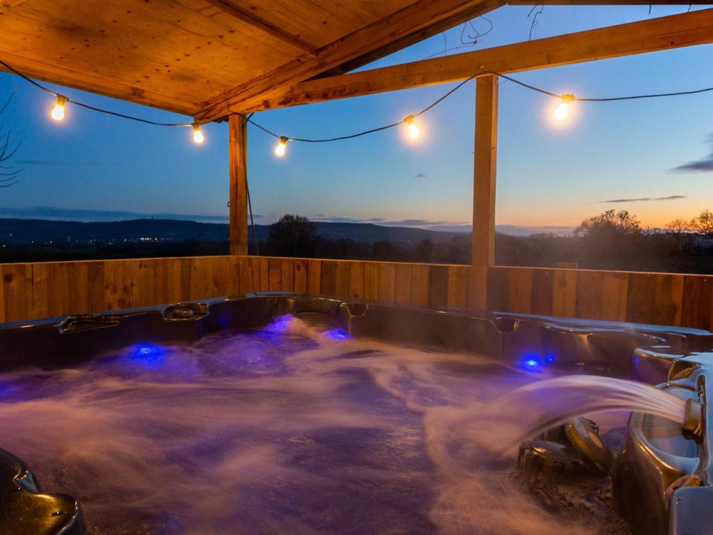 a hot tub in a deck with a sunset at Woodlands in Milverton