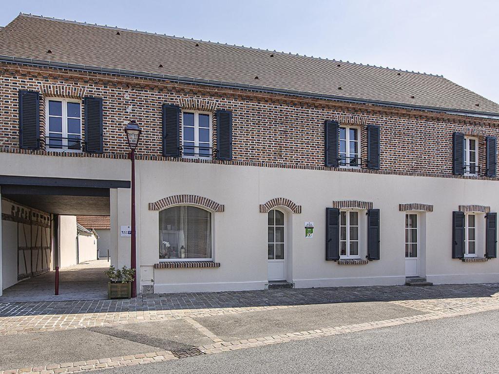 a brick building with black shuttered windows and a street light at Gîte de charme en Sologne, 15 pers., 5 ch., accès PMR, parking privé, tout inclus, animaux acceptés - FR-1-491-427 in Marcilly-en-Gault