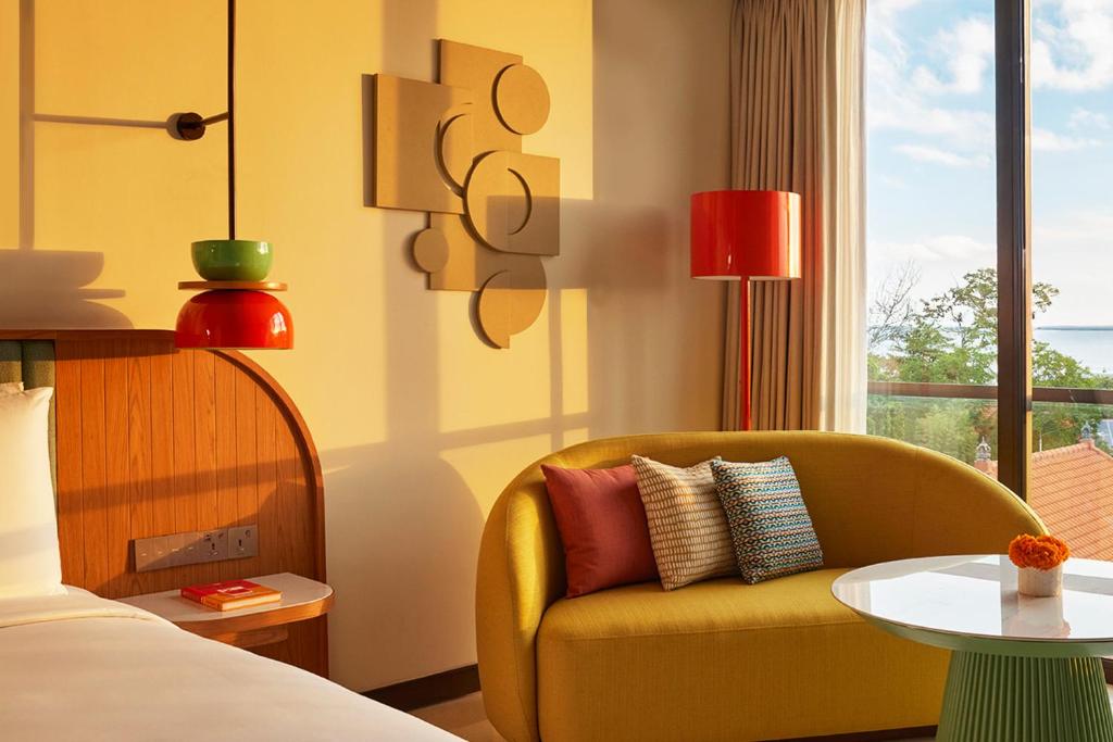 塞米亚克Kleo Seminyak, part of JdV by Hyatt的酒店客房配有黄色椅子和桌子