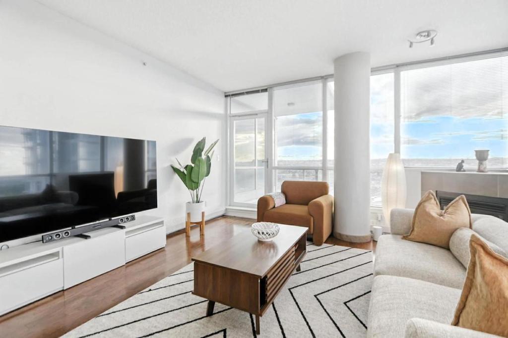 a living room with a couch and a tv at 17th Avenue Paranomas Escape in Calgary