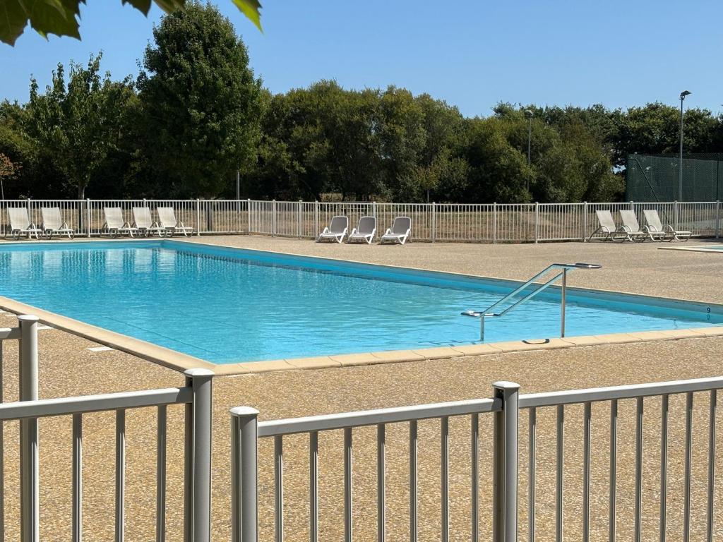 une piscine avec des chaises et une clôture dans l'établissement Maison calme avec piscine et proche plage à Talmont-Saint-Hilaire - FR-1-197-488, à Saint-Hilaire-de-Talmont