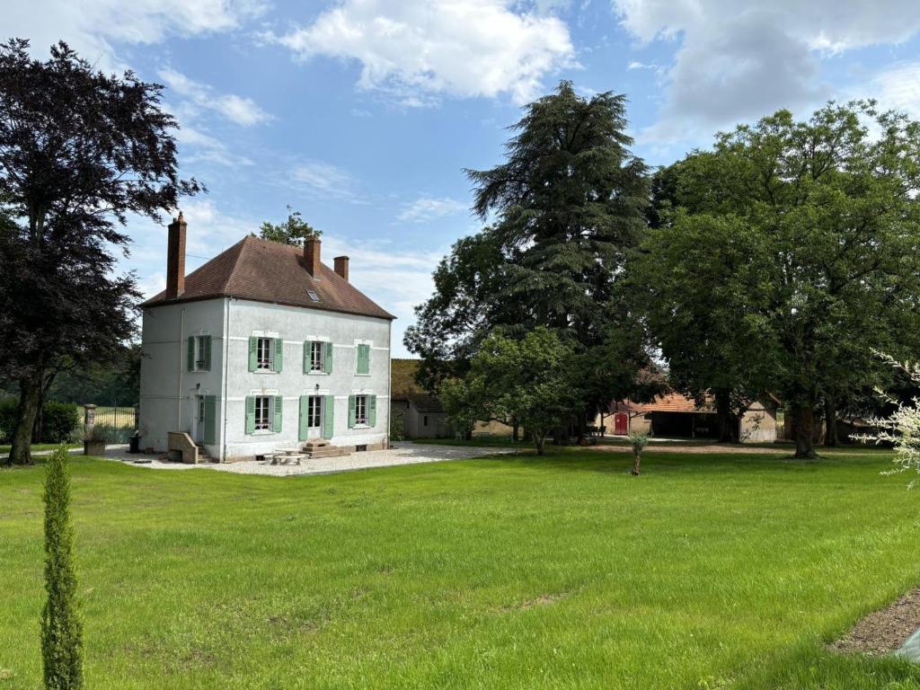 an old white house with a large grass field at Maison Bourgeoise de Charme avec Spa, Parc et Activités - FR-1-489-541 in Jaligny