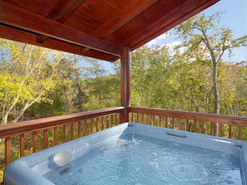 a hot tub on the deck of a porch at Sweet Dreams Holiday home in Gatlinburg