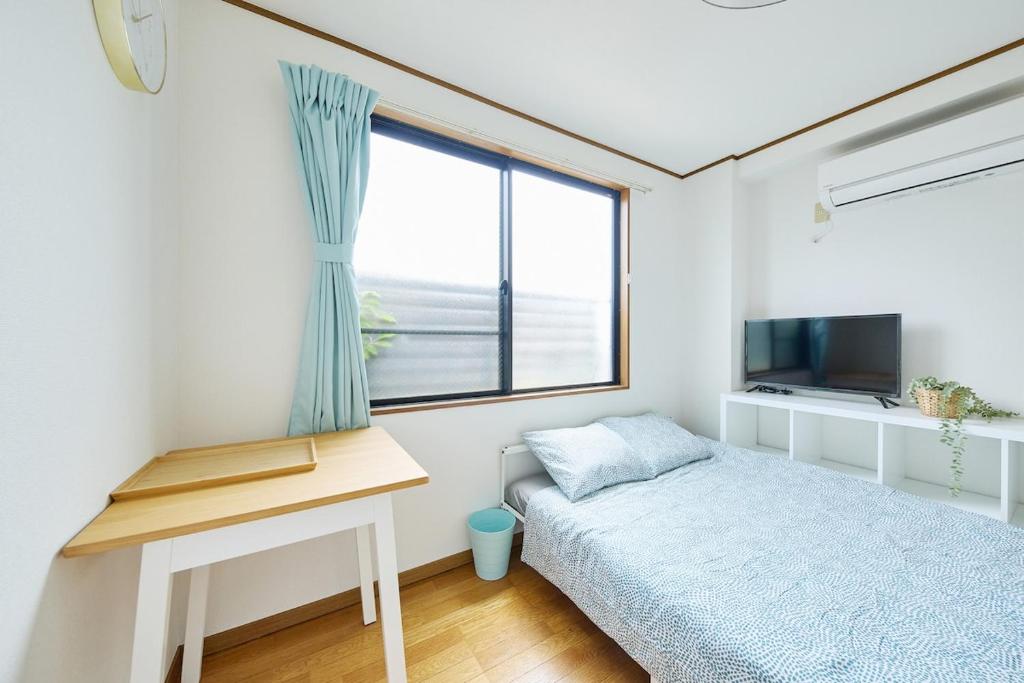 una piccola camera da letto con un letto e una finestra di KYOTO R01 - 10 sec walk-Ryoanji Station a Kyoto