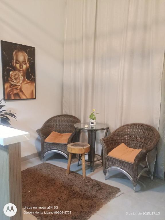a living room with three chairs and a table at Flat no Garden I in Rondonópolis