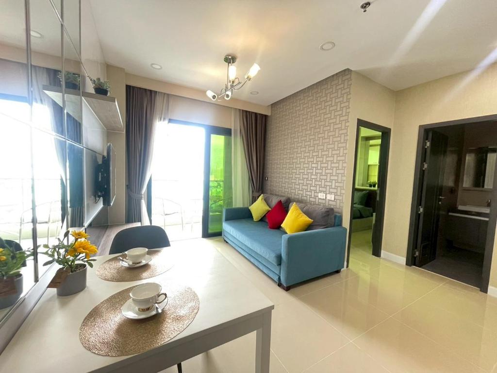 a living room with a blue couch and a table at Dusit Grand Condo View Jomtien By Snap Hosting in Jomtien Beach