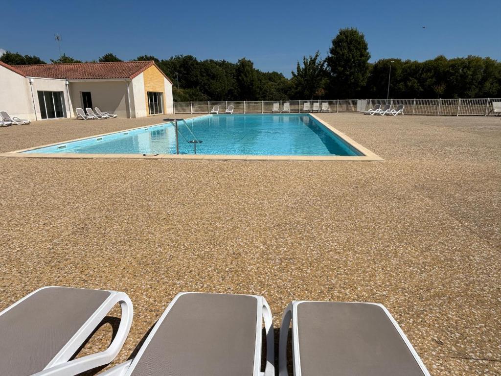 a swimming pool with two lounge chairs in a yard at Maison 2 chambres au calme avec piscine, proche plages et commerces - FR-1-197-484 in Talmont-Saint-Hilaire