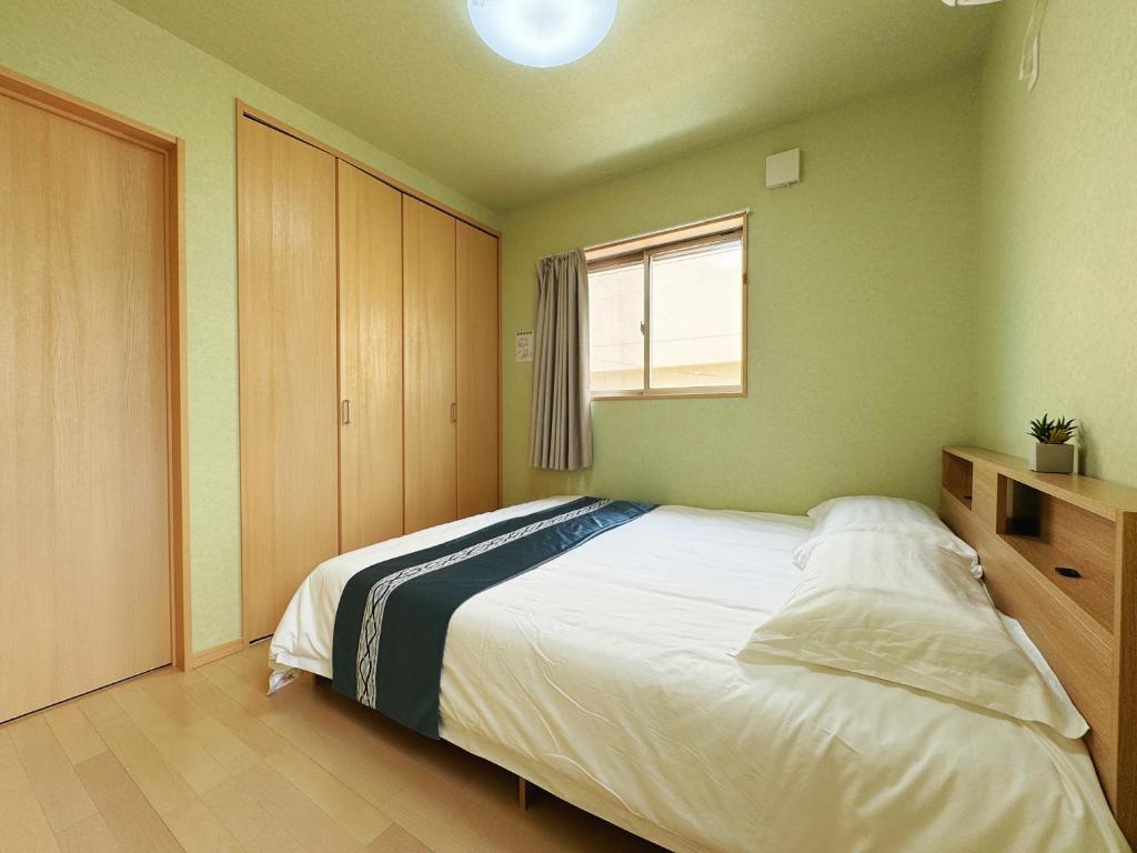 静舍JR难波站徒步8分Jr芦原桥徒步5分梅田心斋桥道顿堀黑门市场关西机场一站直达日式整栋一户建 في أوساكا: غرفة نوم بسرير كبير ونافذة