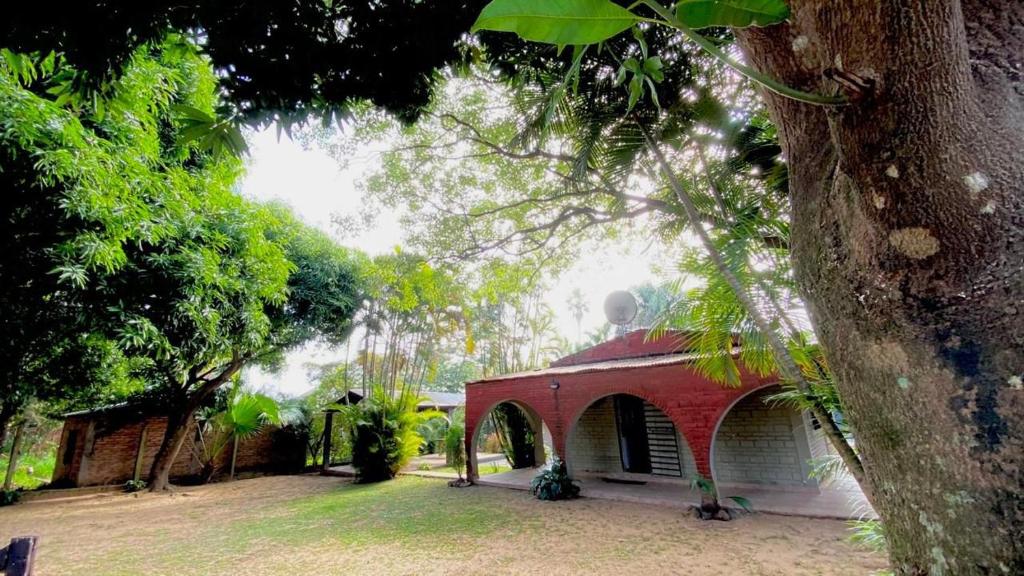 a building with a red roof next to a tree at Casa Don Tori Paso de la Patria in Paso de la Patria