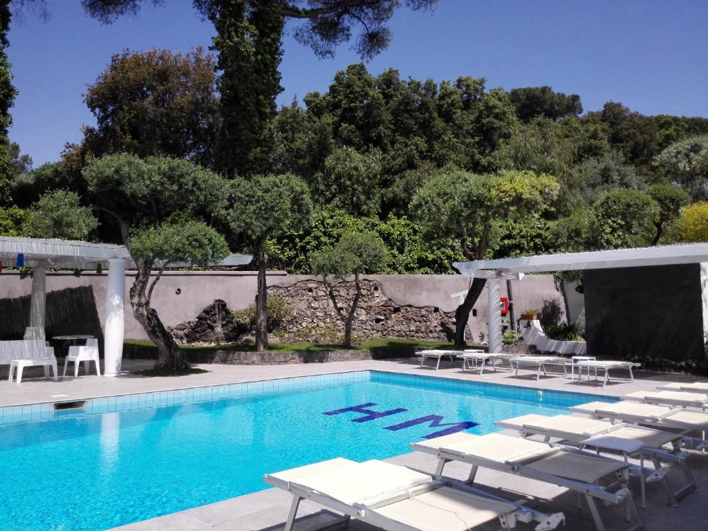 uma piscina com espreguiçadeiras e um resort em Hotel Marad em Torre del Greco