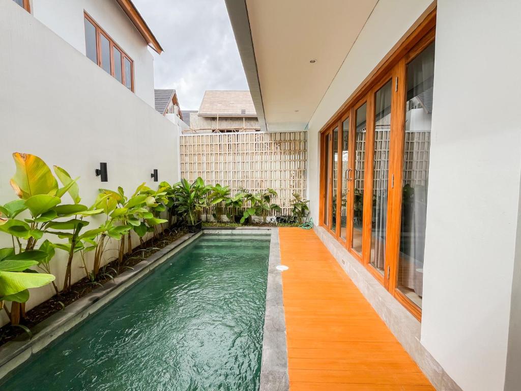 an indoor pool in the middle of a building with plants at KANGIN House Sanur in Ketewel