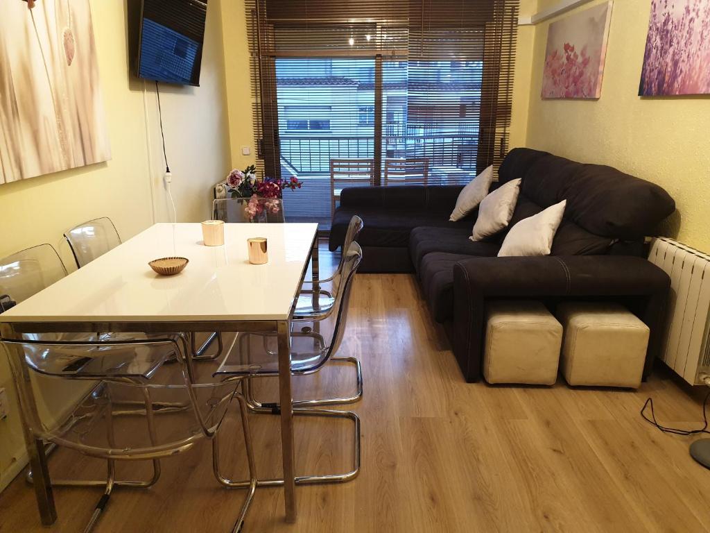 a living room with a table and a black couch at Nice and sunny apartment near Barcelona in Mollet del Vallès