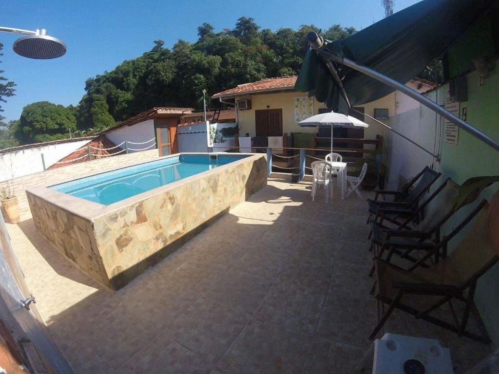 a swimming pool on a patio next to a house at Leo's Clan Beach Hostel in Paraty