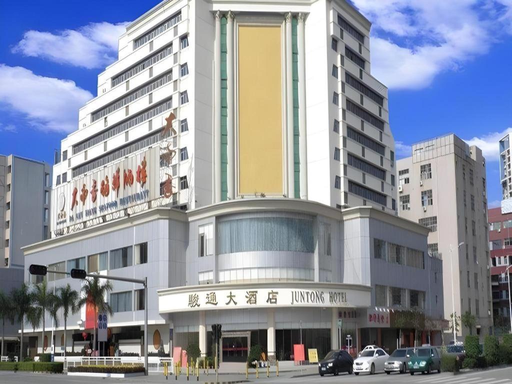 a large building with cars parked in front of it at Juntong Hotel in Bao'an
