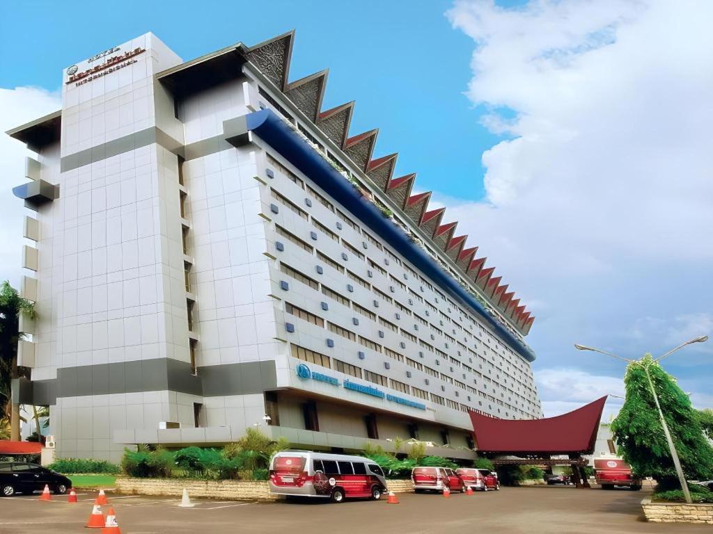 a large building with cars parked in front of it at Danau Toba Hotel International in Medan