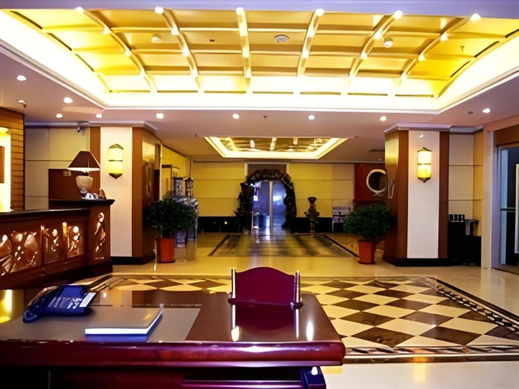 a lobby of a hotel with a desk and a hallway at Longda Ruiji Business Hotel Harbin in Harbin