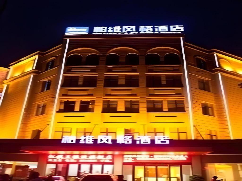 un grand bâtiment avec une enseigne au sommet dans l'établissement Biway Fashion Hotel - Puyang Huanghe Road, à Zhongyuanyoutian