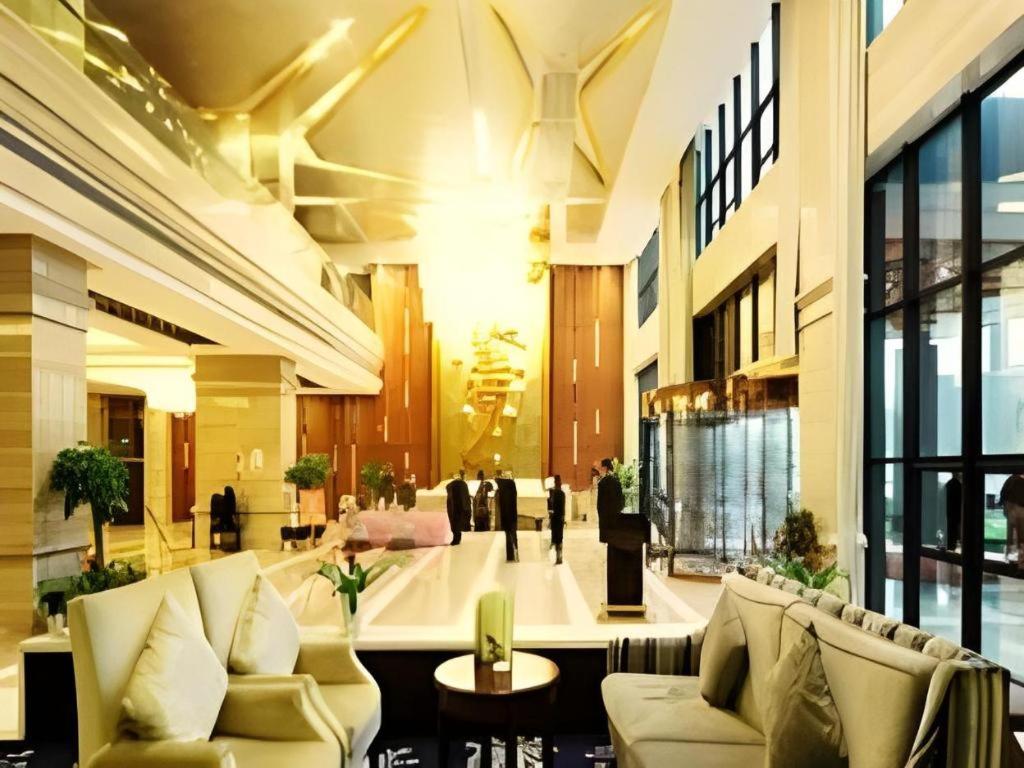 a lobby with couches and tables in a building at Ningbo East Shipu Hotel in Ningbo