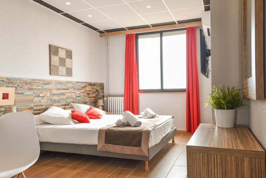 Schlafzimmer mit einem Bett und einem Fenster mit roten Vorhängen in der Unterkunft Mar I Sol Logis in Saint-Cyprien