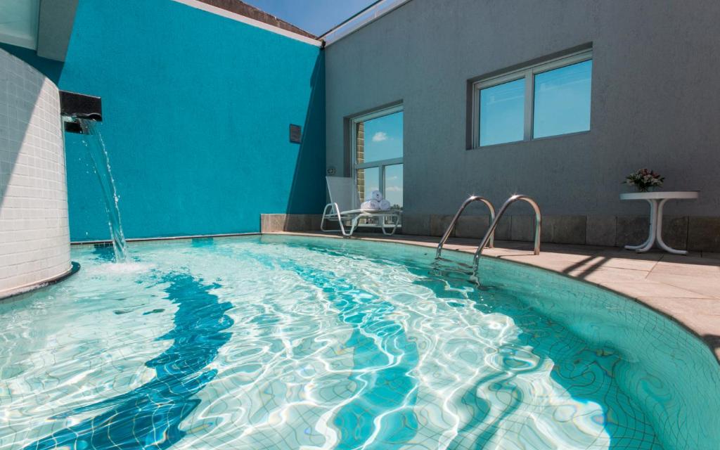 a large swimming pool with a blue wall at Transamerica Executive Perdizes in São Paulo