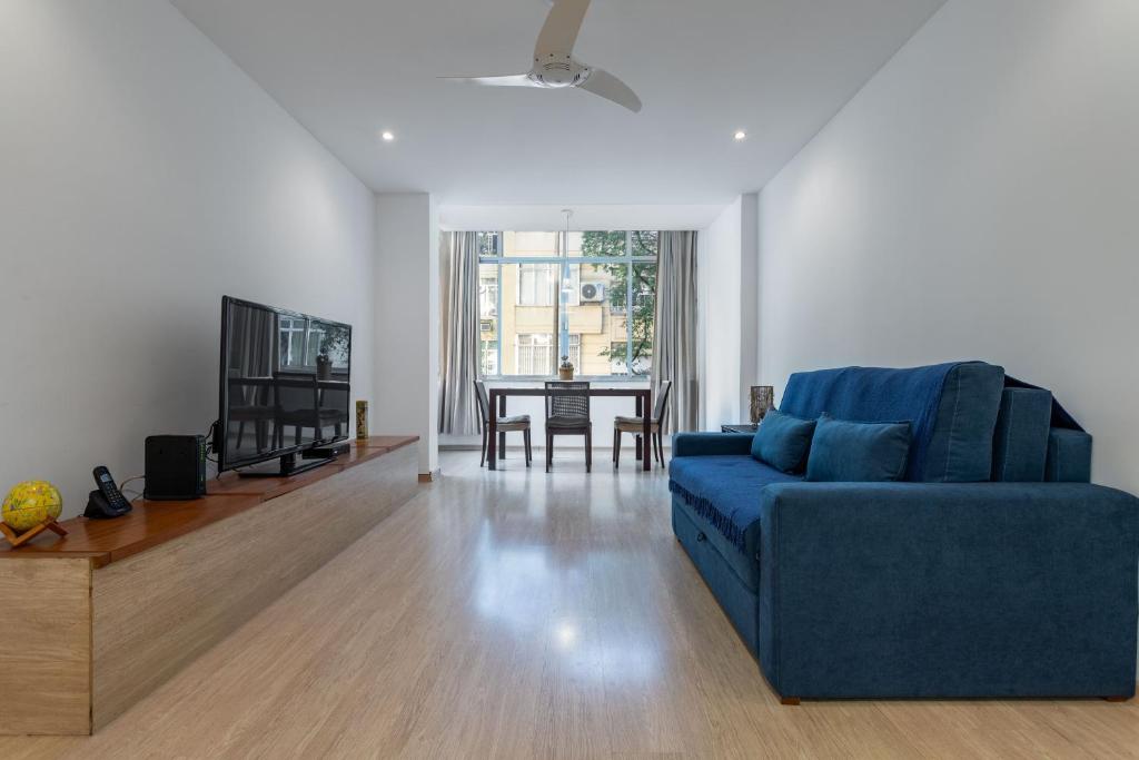 a living room with a blue couch and a table at Espaçoso - Charme House - Copacabana in Rio de Janeiro