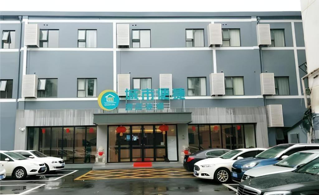 a parking lot with cars parked in front of a building at City Comfort Inn Wuhan Hangkong Road Tongji Hospital in Wuhan
